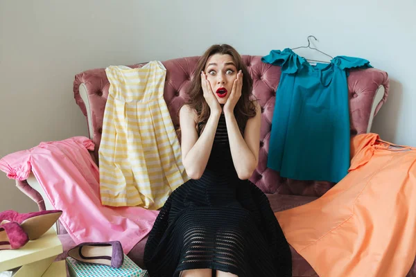 Ziemlich frustrierte Frau im Kleid sitzt auf einem Sofa — Stockfoto