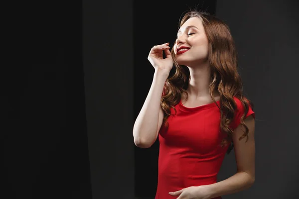 Feliz concurso jovem mulher em pé vestido vermelho e sorrindo — Fotografia de Stock