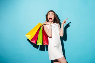 Renkli alışveriş torbaları tutan mutlu heyecanlı kız portresi