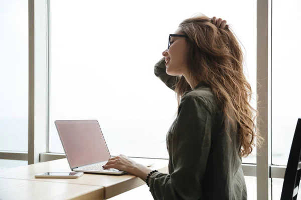 Vista posterior de la mujer con pantalla en blanco de la computadora portátil — Foto de Stock