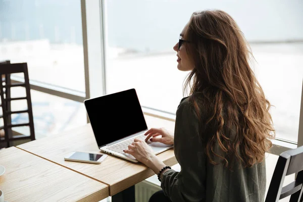 Baksidan på kvinna med blank skärm på laptop — Stockfoto