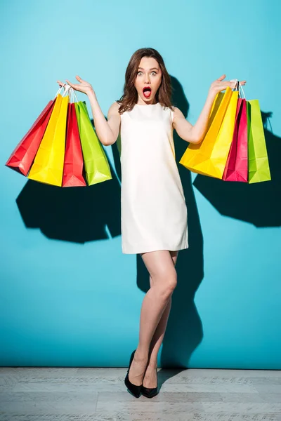Портрет щасливої дівчини, що тримає барвисті сумки для покупок — стокове фото