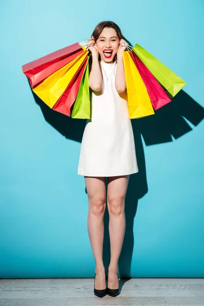 Retrato de una chica feliz emocionada sosteniendo coloridas bolsas de compras — Foto de Stock