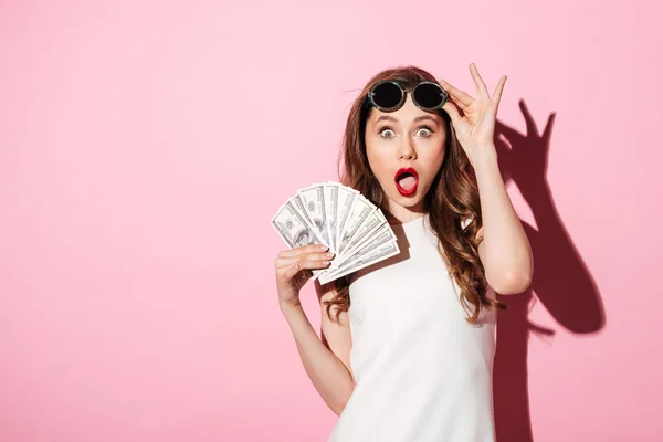 Shocked young brunette woman holding money — Stock Photo, Image