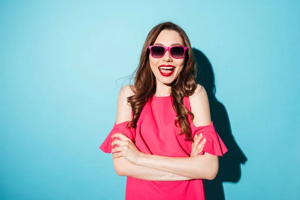 Souriant femme gaie en robe et lunettes de soleil regardant la caméra — Photo