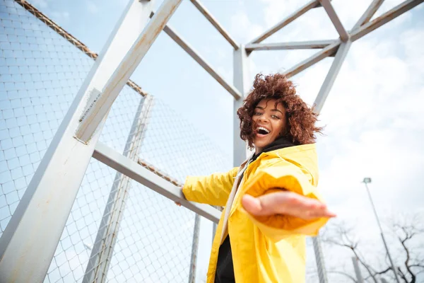 Sorrindo Africano encaracolado jovem senhora vestindo casaco amarelo — Fotografia de Stock