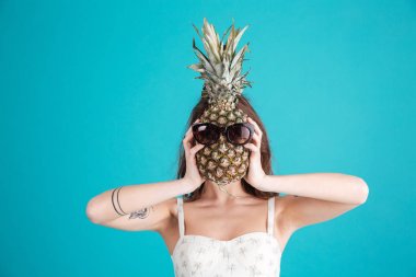 Kafasını ananas arkasında saklanıyor genç bir kızın portresi