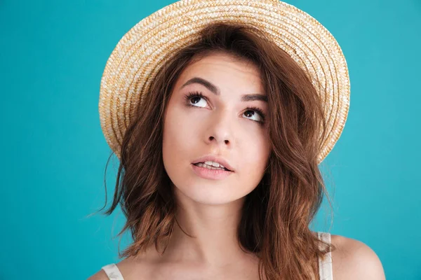 Doordachte jonge vrouw in stro hoed benieuwd en weg op zoek — Stockfoto