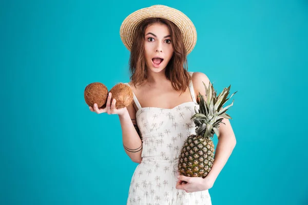 Menina em roupas de verão segurando dois cocos e abacaxi — Fotografia de Stock