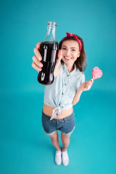Smiling young lady holding aerated sweet water. Focus on water. — Stock Photo, Image
