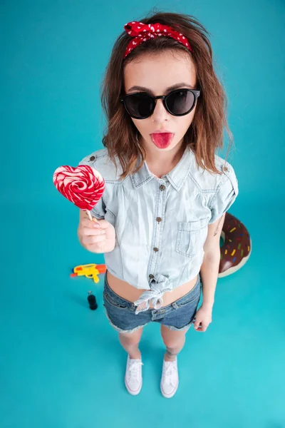 Retrato de una chica divertida y elegante en gafas de sol mostrando la lengua — Foto de Stock
