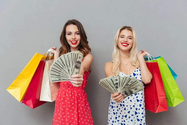 Дві жінки тримають сумки і показують гроші — стокове фото