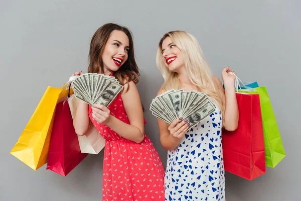 Дві жінки тримають сумки і гроші — стокове фото