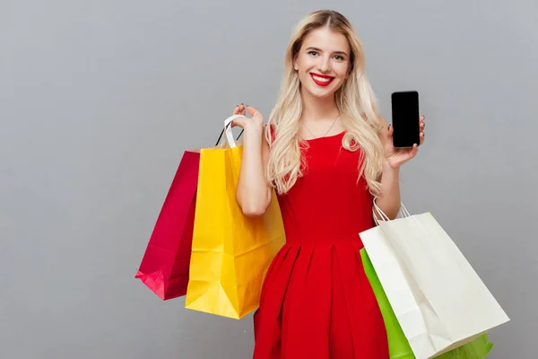 Bionda con telefono e borse — Foto Stock