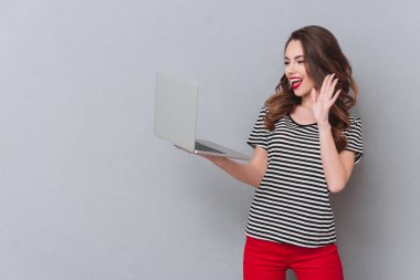 Mutlu genç bayan gri duvar arkadaşlarınızla konuşurken üzerinde ayakta