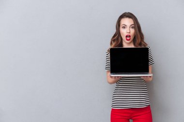 Dizüstü bilgisayarın görüntü gösterilen şok genç bayan.