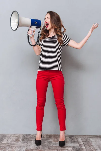 Retrato de comprimento total de mulher gritando ao megafone — Fotografia de Stock