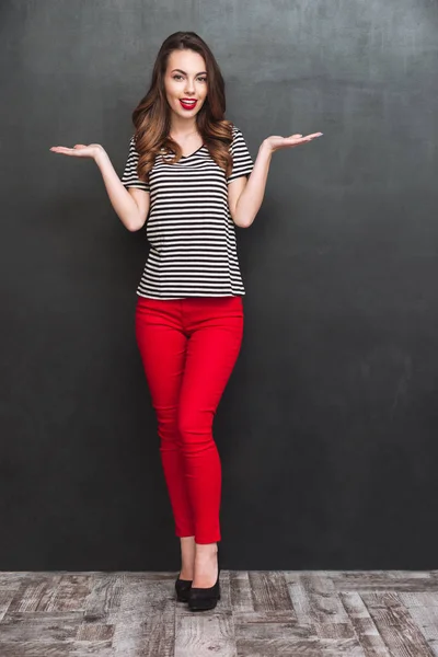 Retrato de cuerpo entero de una mujer sonriente sosteniendo un espacio en libra —  Fotos de Stock