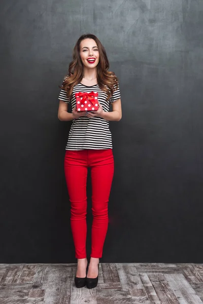 Full length portrait of woman holding a gift box
