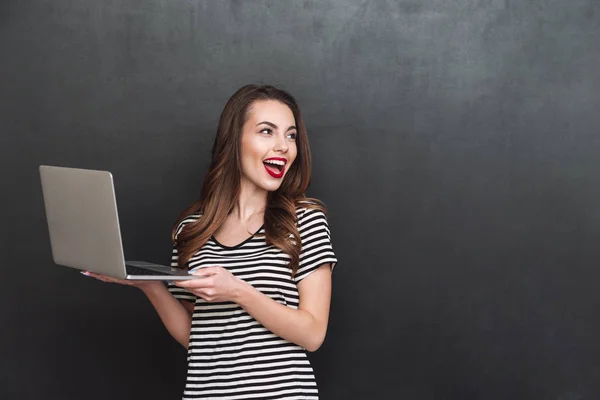 Mulher feliz segurando computador portátil — Fotografia de Stock