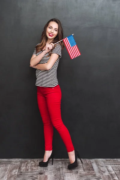 Portrait complet d'une femme souriante tenant le drapeau des États-Unis — Photo