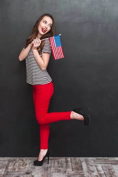 Retrato de comprimento total de mulher muito sorridente segurando bandeira dos EUA — Fotografia de Stock