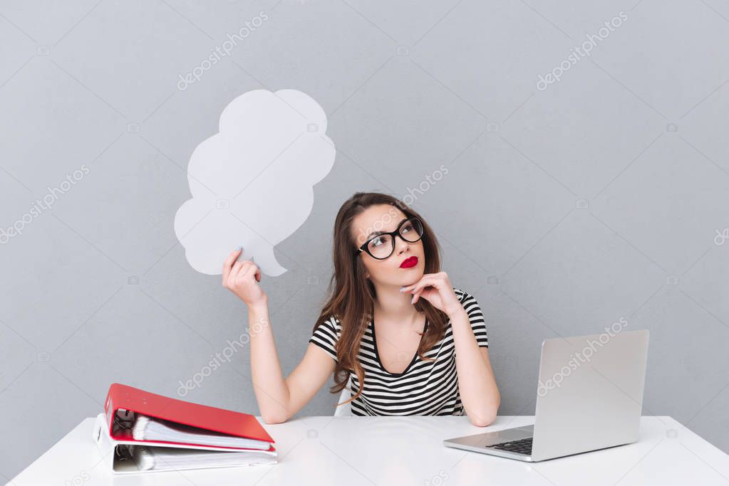 Thinking young lady holding empty thoughts bubble.