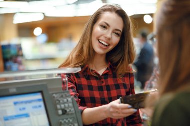 Gülümseyen genç bayan süpermarket dükkanda ayakta