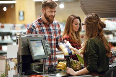 ?heerful genç adam süpermarket dükkanda ayakta