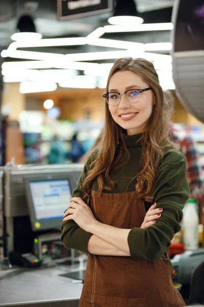 Glückliche Kassiererin am Arbeitsplatz im Supermarkt — Stockfoto