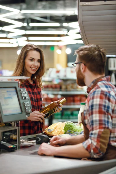 Happy young lady standing near cashier's desk — Stock Photo, Image