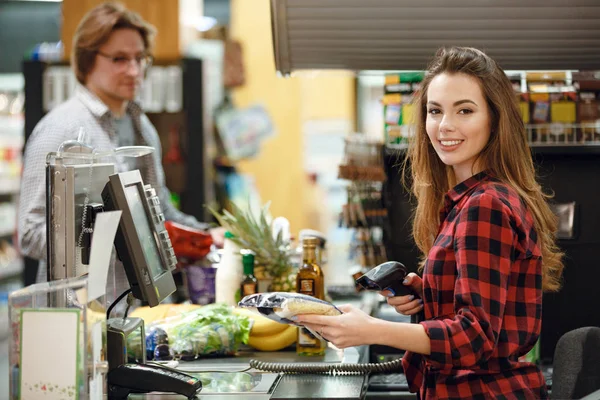 Χαμογελώντας Ταμείο γυναίκα στο χώρο εργασίας σε κατάστημα σούπερ μάρκετ — Φωτογραφία Αρχείου