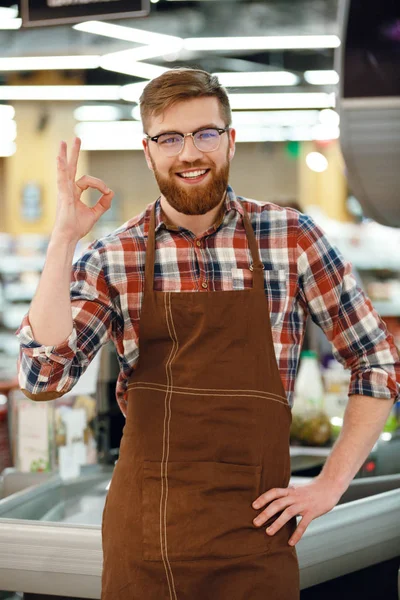 Glada kassan man på arbetsytan i snabbköpet butik. — Stockfoto