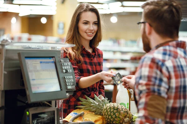 Woman gives credit card to cashier man — Stock Photo, Image
