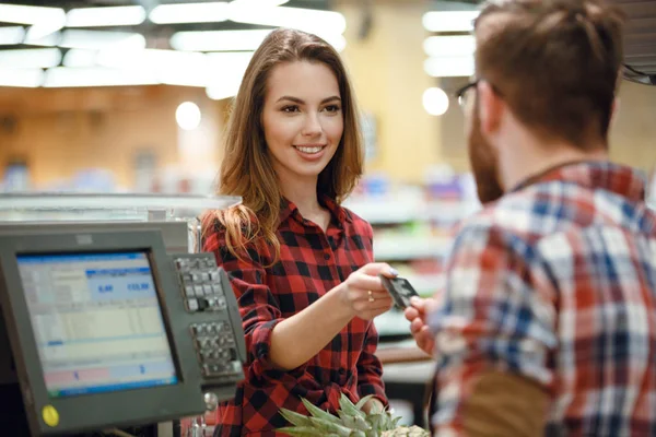 Gelukkig jongedame die permanent in de buurt van kassier Bureau — Stockfoto