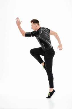 Tam uzunlukta bir genç konsantre sporcu kulaklık atlar portresi