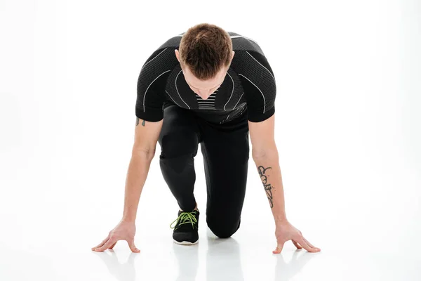 Portrait of a concentrated male sprinter preparing to start running — Stock Photo, Image