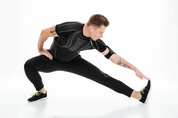 Portret van een knappe sportman rekoefeningen te doen voordat het joggen — Stockfoto