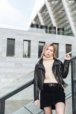 Açık havada sigara tutan ciddi genç sarışın Bayan.