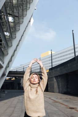 Ciddi genç sarışın Bayan ayakta açık havada kapalı gözleriyle.