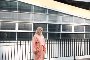 Ciddi genç sarışın Bayan açık havada yürüyüş