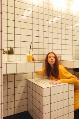 Kafede oturan genç redhead kıvırcık Bayan konsantre
