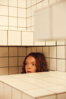 Masanın altından kafede oturan ciddi genç redhead kıvırcık Bayan