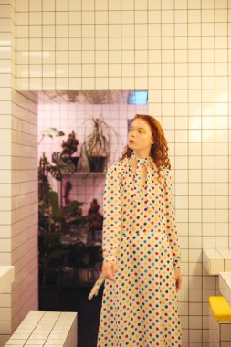 Genç redhead kıvırcık Bayan kafede ayakta konsantre