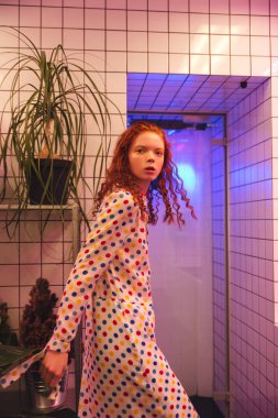 Ciddi genç redhead kıvırcık Bayan hela yakınındaki kafede ayakta
