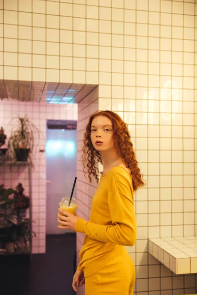 Concentrated young redhead curly lady standing in cafe — Stock Photo, Image