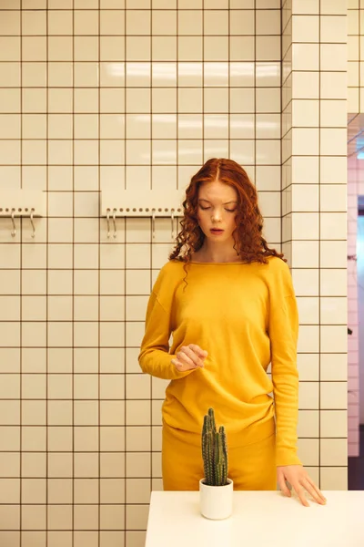 Concentrated young redhead curly lady standing in cafe — Stock Photo, Image