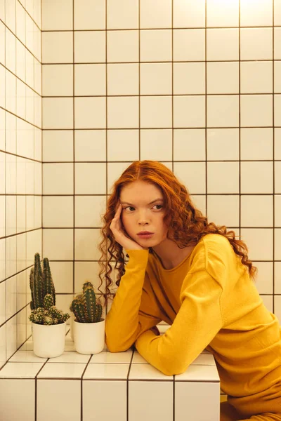 Concentrated young redhead curly lady sitting in cafe — Stock Photo, Image