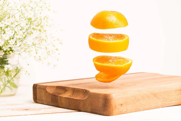 切木砧板上空飞行的整个橙子 — 图库照片