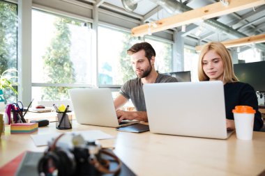 Office coworking oturan genç meslektaşları konsantre